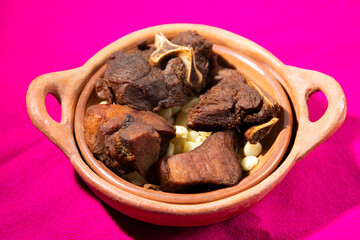 comida peruana, chicharrón con mote en doble plato artesanal fondo tela purpura