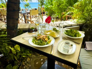 Papier Peint photo autocollant Plage de Seven Mile, Grand Cayman View of a lunch on a terrace by Seven Mile Beach in the Caribbean, Grand Cayman