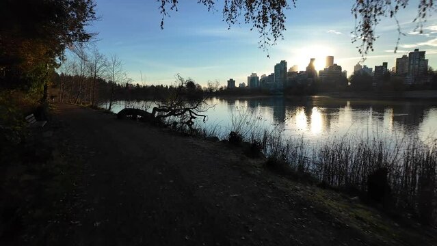 View of Lost Lagoon in famous Stanley Park. Sunny Fall Morning. Modern city