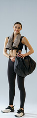 Woman wearing sportswear with sports bag after training on studio background. High quality photo