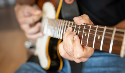 Man hand playing on electric guitar closeup. Musician performing live with acoustic string...