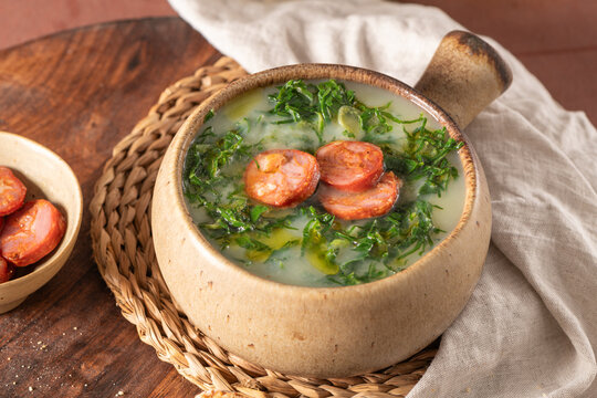 Caldo verde popular soup in Portuguese cuisine. Traditional ingredients for caldo verde are potatoes, onion, garlic, collard greens, chorizo , olive oil and salt. Is a comfort soup