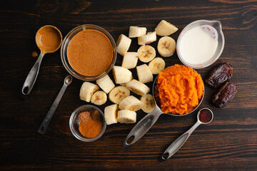 Pumpkin Pie Smoothie Bowl Measured Ingredients: Frozen banana  pumpkin puree, oat milk, and other smoothie ingredients in measuring cups and spoons
