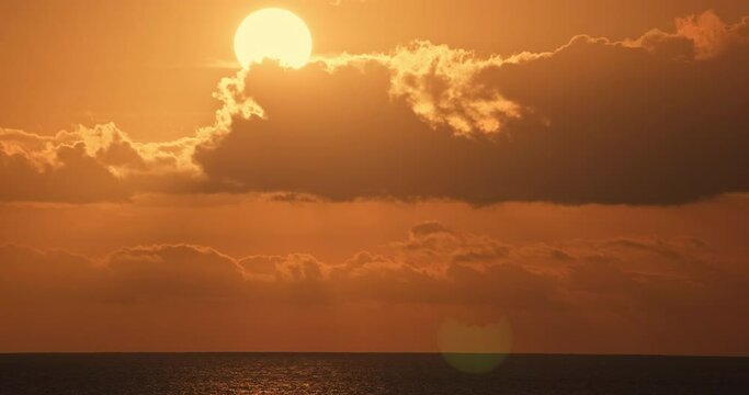 4K sunset dusk twilight sundown dark clouds ocean horizon. Golden magic hour dramatic sky with glowing afterglow and serene evening reflection