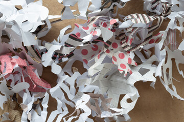 folded and cut crushed paper sheet with patterns arranged on a brown paper surface