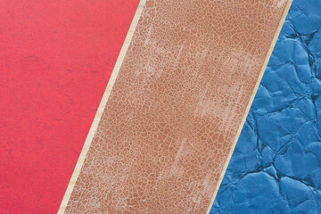 red, brown, and blue scrapbooking paper sheets (each with a pattern) arranged diagonally  on wood