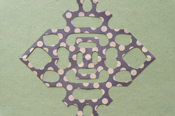 isolated decorative paper design mimicking the delicate pattern of snowflakes on rough green paper