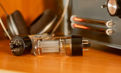 Radio tube close-up, headphones and lamp indicator in the background