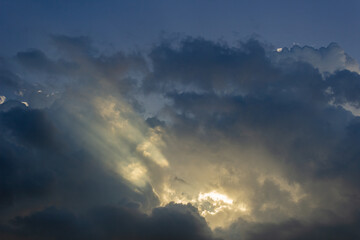 Naklejka na ściany i meble Dramatic cloudscape with sunbeams and rays of light
