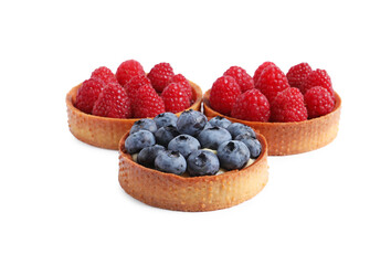 Tartlets with different fresh berries isolated on white. Delicious dessert