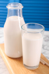 Glassware with tasty milk on white table, closeup