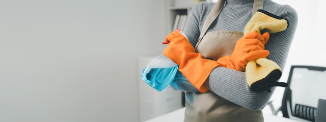 Wear an apron and rubber gloves to protect against cleaning chemicals, Janitor cleaning the office, Use a towel to wipe the table, Wear rubber gloves when working with cleaning chemicals,