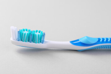 One plastic toothbrush on light background, closeup