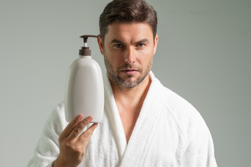 Cosmetic beauty products. Beauty man with cosmetic bottle with dispenser pump for liquid soap, gel...
