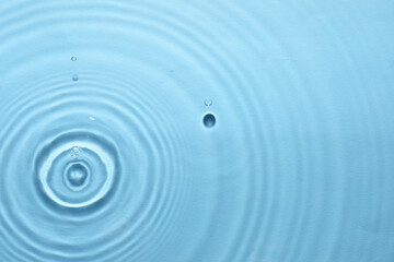 Rippled surface of clear water on light blue background, top view