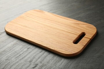 One wooden cutting board on dark grey table