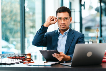 Attractive Asian male lawyer businesspeople in blue suit working at desk.