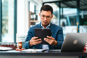 Attractive Asian male lawyer businesspeople in blue suit working at desk.