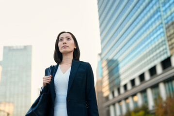 空を見上げるビジネスウーマン