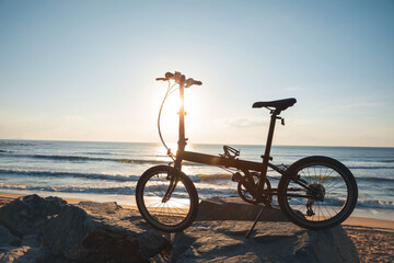 Obraz premium A folding bike on sunrise seaside road