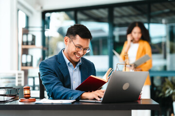 Attractive Asian businessman and an African American businesswoman, both in formal suits, intently review a contract paper together.