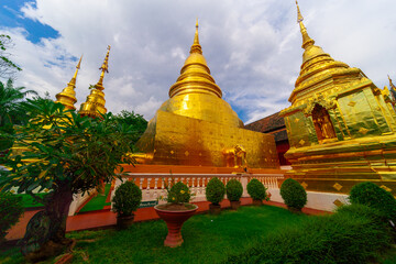 Naklejka premium Beautiful Wat Buddhist temples in Chiangmai Chiang mai Thailand. Decorated in beautiful ornate colours of red and Gold and Blue. Lovely sunset