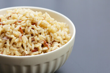 Cooked brown rice on dark background.