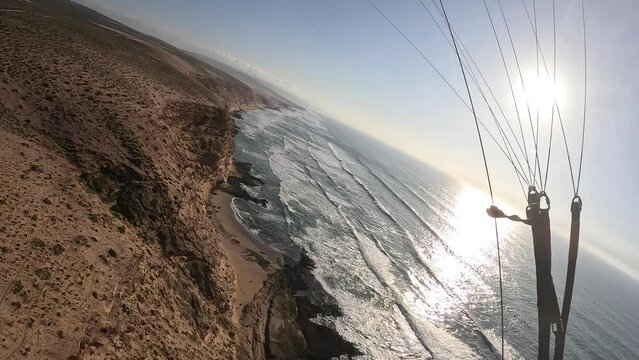 Fly like a bird on paragliding wing at beautiful sunset in Ocean coast, Freedom of free flight,Parapente Morocco Africa seaside,Beauty of paragliding free flying-extreme sports
