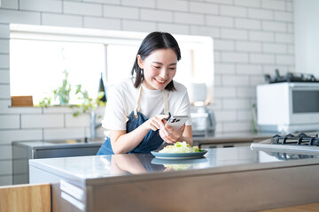Fototapeta premium 料理をスマホで撮影する若い日本人女性