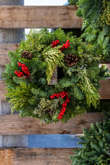 Christmas holiday spirit with fresh wreaths made out of evergreen boughs, pinecones, and red berries
