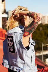 Back, tattoo and a woman tying her hair outdoor in the city for travel, freedom or adventure on...
