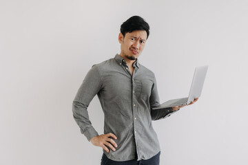 Asian man with beard wear grey shirt, dislike unsatisfied face, holding notebook hand gesture, unhappy face looking at camera isolated over white background wall.