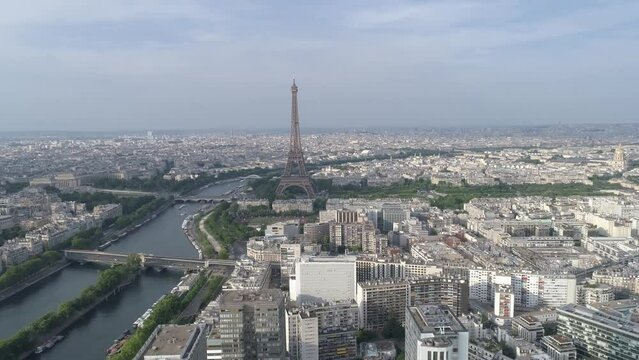 High drone footage of the urban buildings on the Seine and Eiffel Tower at sunset in Paris, France