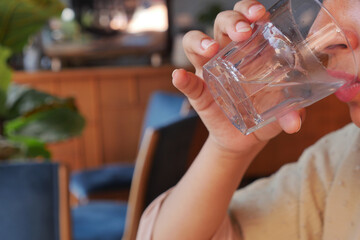 women drinking a glass of water at cafe 
