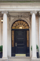 entrance to wealth and opportunity knocking at a classical front door with stone columns of an historic building entrance vertical - obrazy, fototapety, plakaty