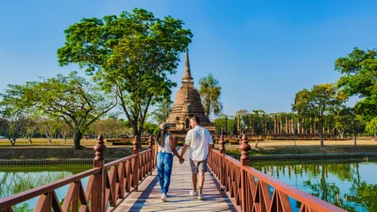 Foto op Canvas Some men and women visit Wat Sa Sit, Sukhothai Old City, Thailand. Ancient city and culture of South Asia Thailand, A couple visit Sukhothai Historical Park © Fokke Baarssen