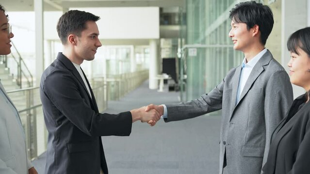 A multinational group shaking hands in the lobby.
People in white coats and sales staff.