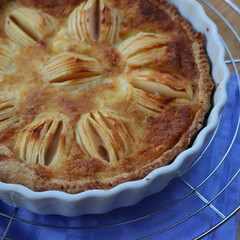 Top view of tasty apple pie with cream and sliced fruits on wooden table
