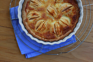 Top view of tasty apple pie with cream and sliced fruits on wooden table