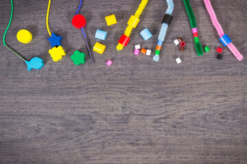 Thread, creative sticks and beads used to making bracelets, learn counting and arranging various...