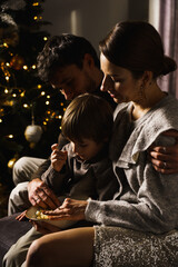 Happy family  celebrate Christmas, watch movies and eat popcorn and pizza near the New Year tree. Vertical photo