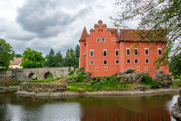 Fototapeta na wymiar The old castle Červená lhota in South Bohemia. A castle with a brick bridge over a lake. Tourist attraction in the Czech Republic.