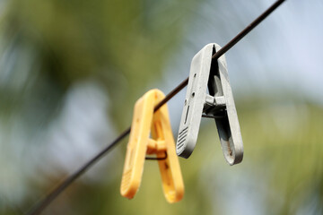 Plastic Clothespin on a hanger. Colored old cloth clips on a cloth rope.