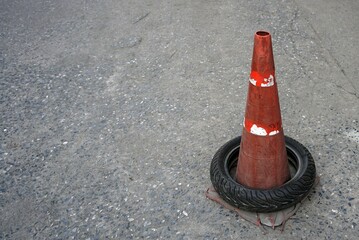 Old traffic cone with old motorcycle tires into on the streets in the city.