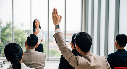 Active participation in a conference seminar classroom, with a large group raising hands. The answers lie within the engaged audience, signifying collaborative learning.