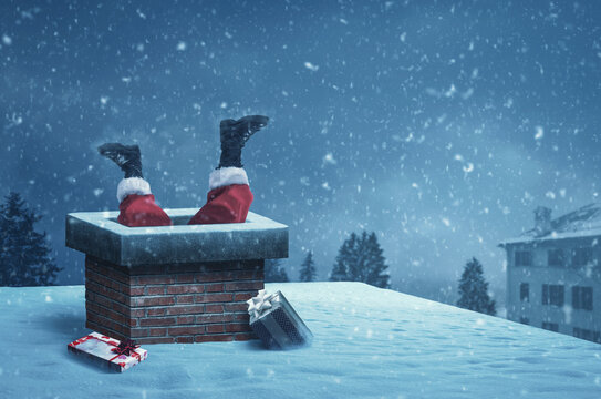 Funny Santa Claus stuck with feet up in a chimney