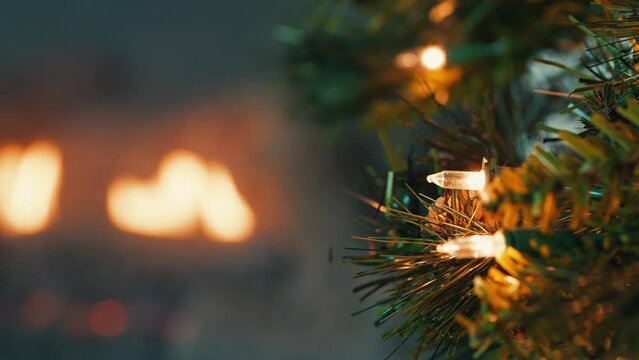 Christmas lights on a fake tree with a fire in the background 