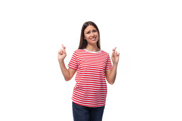 A 35 year old European lady in a red striped T-shirt crossed her fingers in hope
