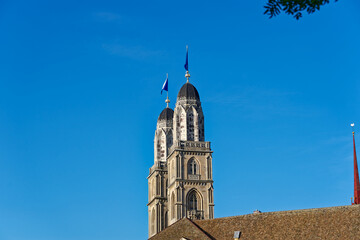 Fototapeta na wymiar Twin towers with flags of City of Zürich and Canton Zürich on top of church towers of protestant church Great Minster on a sunny summer evening. Photo taken July 7th, 2023, Zurich, Switzerland. 
