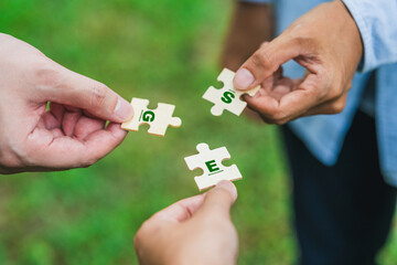 ESG Concept of teamwork and partnership Hands join Jigsaw puzzle pieces with global community...